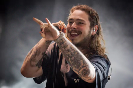 Post Malone performs on stage, exuding energy and charisma, surrounded by a misty backdrop. This HD image captures the essence of his musical artistry.