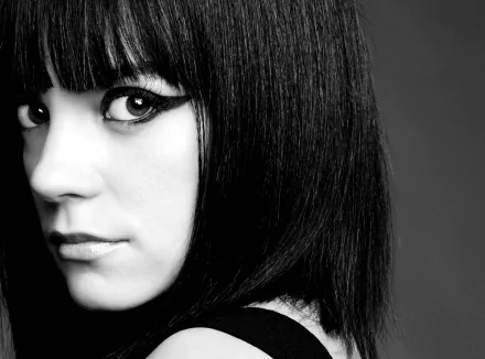 Black and white close-up of singer Lily Allen's face with striking eyeliner, designed as an HD PC desktop wallpaper background.