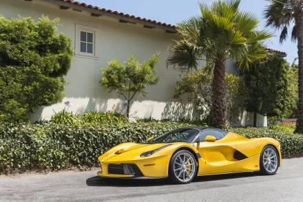 Yellow Ferrari LaFerrari Aperta car — a supercar vehicle parked by a villa; 2K Quad HD PC desktop wallpaper background showing a sleek sports car.