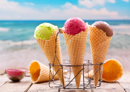 A 4K Ultra HD close-up of three colorful ice cream scoops in waffle cones with a blurred ocean background, showcasing food and depth of field on a PC desktop wallpaper.