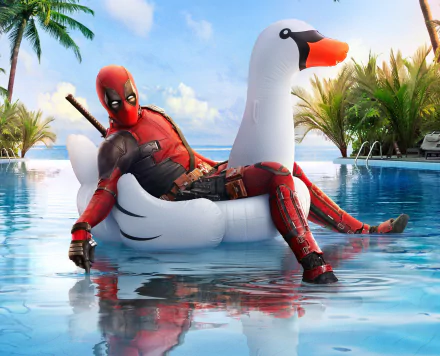 HD desktop wallpaper from the movie Deadpool 2 showing Deadpool relaxing on a white swan pool float in a tropical setting with palm trees in the background.