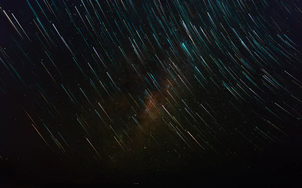 A 4K Ultra HD desktop wallpaper showcasing vibrant star trails streaking across the night sky, highlighting the beauty of nature under a vast, star-filled sky.