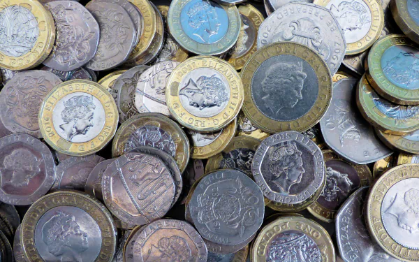 Close-up of various man-made coins, showcasing detailed engravings and metallic textures in a rich mix of colors, captured in 4K Ultra HD for a striking desktop wallpaper.