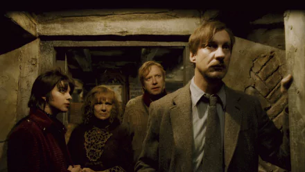 HD PC desktop wallpaper of Remus Lupin with Arthur and Molly Weasley in a tense, dimly lit corridor — scene from the movie Harry Potter and the Half‑Blood Prince.