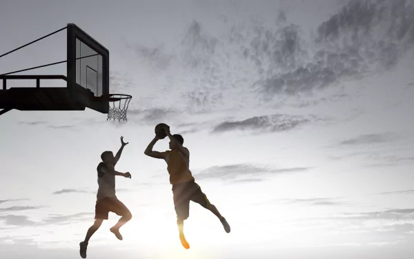 Silhouetted basketball players mid-air near a hoop against a dramatic sunset sky — 4K Ultra HD sports PC desktop wallpaper and background.