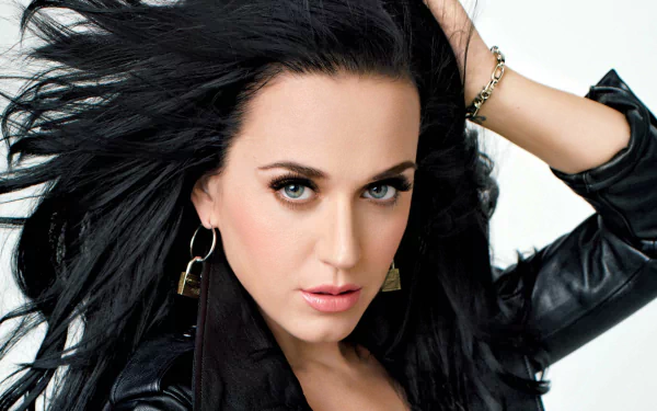 Close-up portrait of Katy Perry with flowing dark hair, wearing a black leather jacket, captured in a 4K Ultra HD music-themed PC desktop wallpaper.