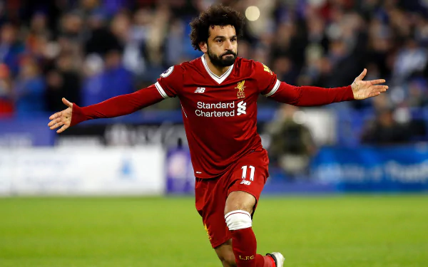 2K Quad HD PC wallpaper: Egyptian soccer star in a red kit celebrates on the pitch with arms outstretched in a dynamic sports action shot.