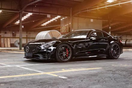 Black Mercedes-AMG GT R supercar parked inside a spacious industrial warehouse, showcased in stunning 4K Ultra HD as a sleek PC desktop wallpaper.