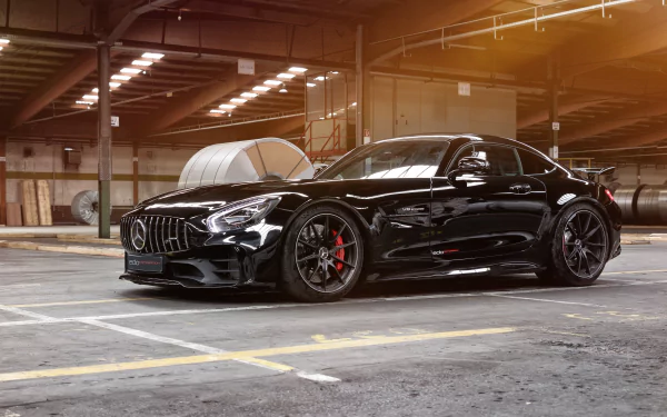 Black Mercedes-AMG GT R supercar parked inside a spacious industrial warehouse, showcased in stunning 4K Ultra HD as a sleek PC desktop wallpaper.