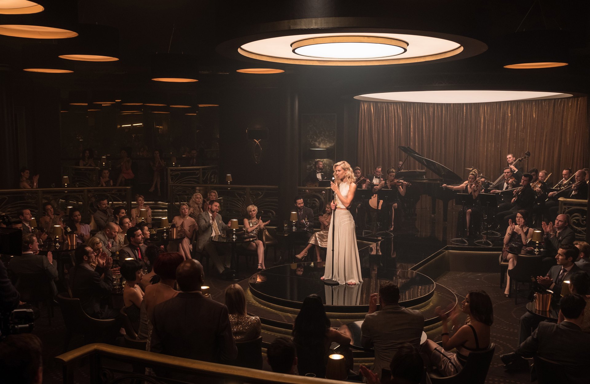 Nightclub scene: actress singing on a circular stage from Mission: Impossible - Fallout — moody 2K Quad HD PC desktop wallpaper.