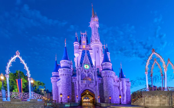 Cinderella Castle at Walt Disney World in Florida, illuminated against a clear evening sky, captured in stunning 4K Ultra HD detail.