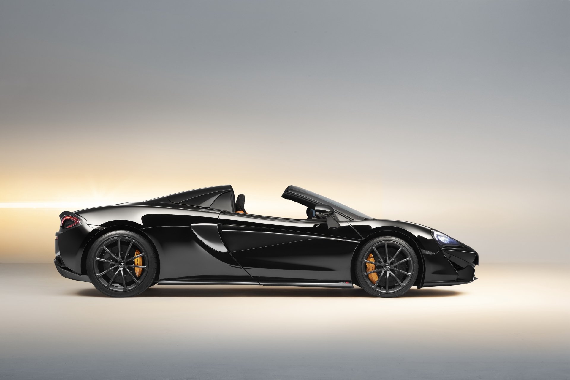 Black McLaren 570S supercar with convertible top down, showcased as a sleek vehicle in a high-resolution 4K Ultra HD desktop wallpaper.