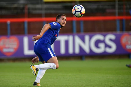 HD desktop wallpaper featuring a player in a blue jersey on the football field, in action during a game, tagged with Eden Hazard.