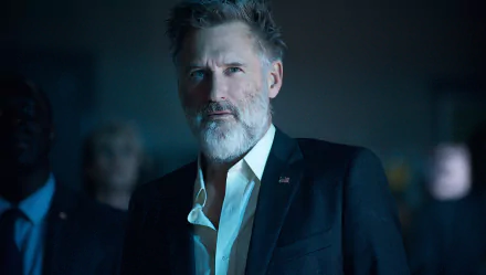 HD desktop wallpaper featuring a focused man in a suit with a beard and intense gaze, providing a compelling and dignified background.