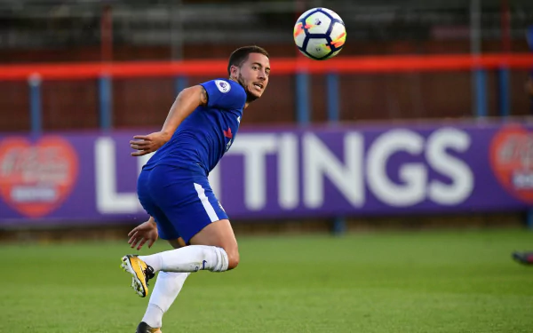 HD desktop wallpaper featuring a player in a blue jersey on the football field, in action during a game, tagged with Eden Hazard.
