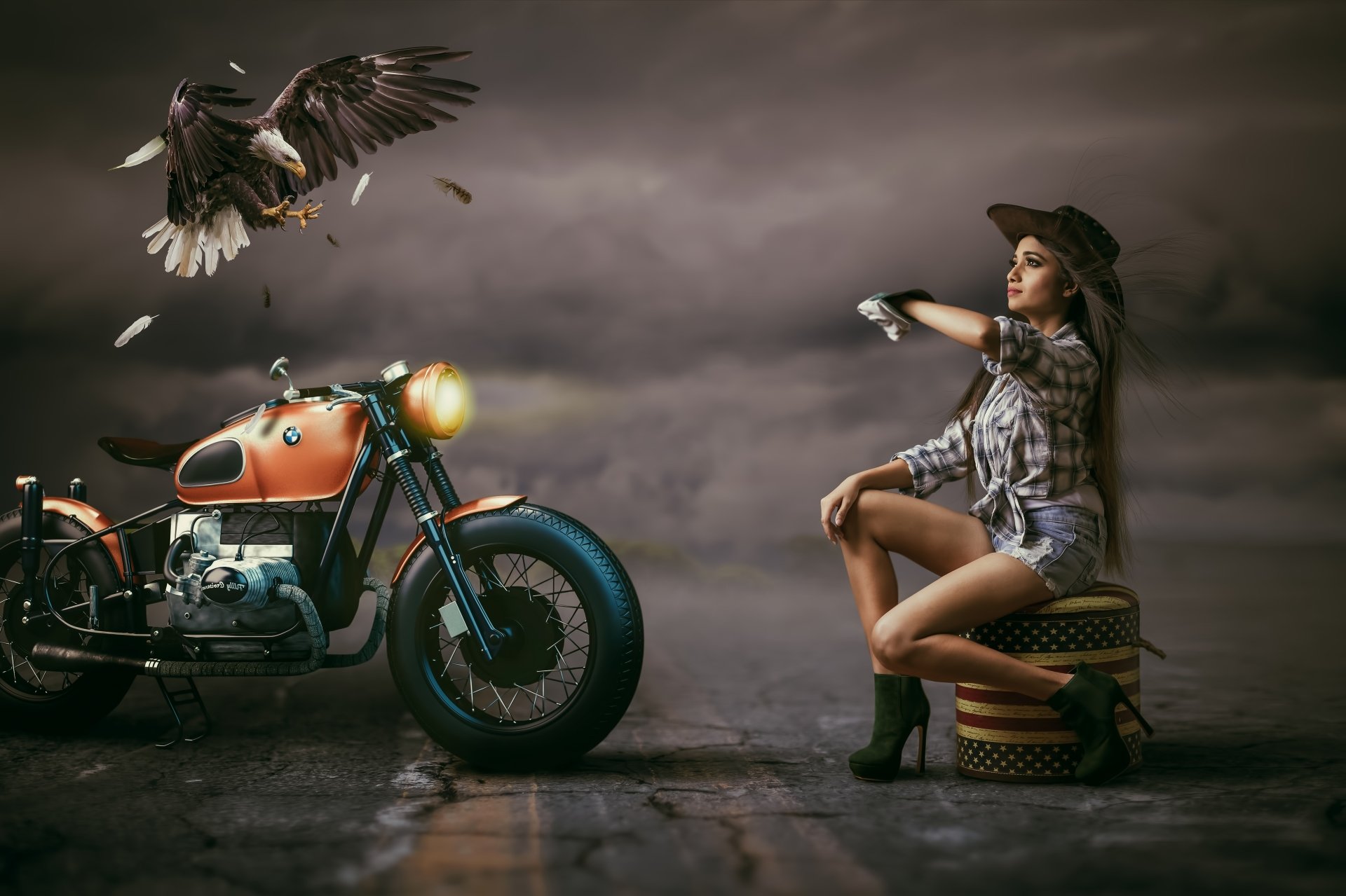 4K Ultra HD wallpaper featuring a long-haired model in shorts and hat seated by a BMW motorcycle, with a bald eagle soaring overhead in a dramatic, moody setting.