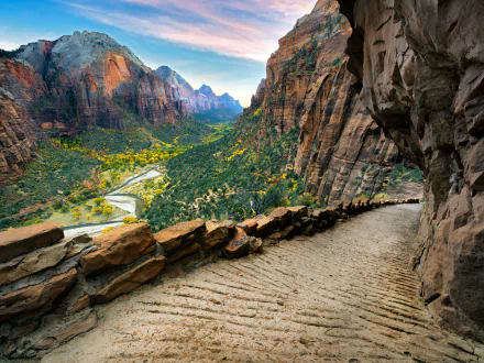 HD desktop wallpaper of Angels Landing in Zion National Park. A breathtaking canyon landscape with a winding trail and lush greenery surrounded by towering rock formations.