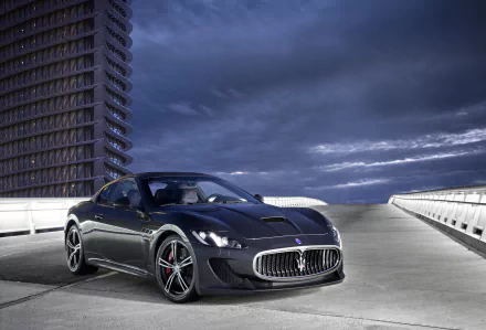 Silver Maserati GranTurismo supercar parked on an empty rooftop with dramatic cloudy sky, captured in high definition as a striking desktop wallpaper.