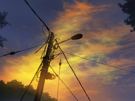 Anime-style HD PC desktop wallpaper featuring a vibrant sky with colorful clouds at sunset, framed by silhouetted trees and an electric pole with wires.