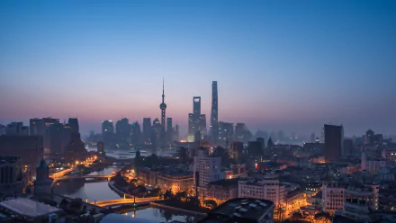 4K Ultra HD wallpaper of Shanghai’s cityscape featuring iconic skyscrapers and illuminated streets at dusk, showcasing a vibrant man-made urban skyline.
