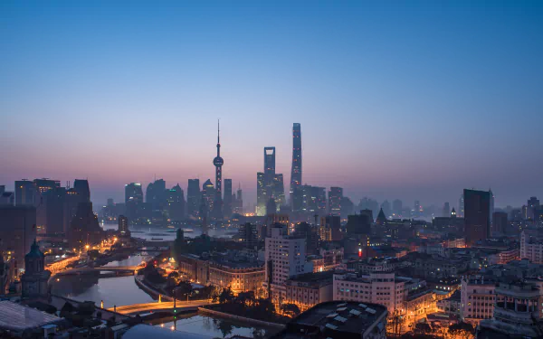 4K Ultra HD wallpaper of Shanghai’s cityscape featuring iconic skyscrapers and illuminated streets at dusk, showcasing a vibrant man-made urban skyline.