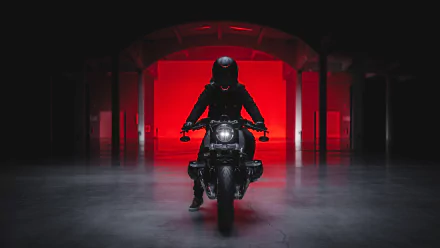 HD PC desktop wallpaper featuring a sleek BMW R nineT motorcycle with a rider in dark gear, set against a dramatic red-lit background in an industrial space.