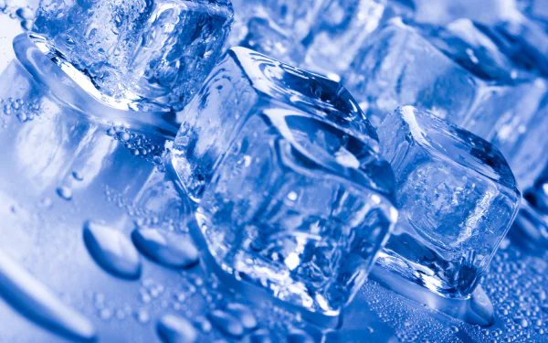 Close-up photography of glistening ice cubes and water droplets in cool blue tones — 2K Quad HD PC desktop wallpaper and background.