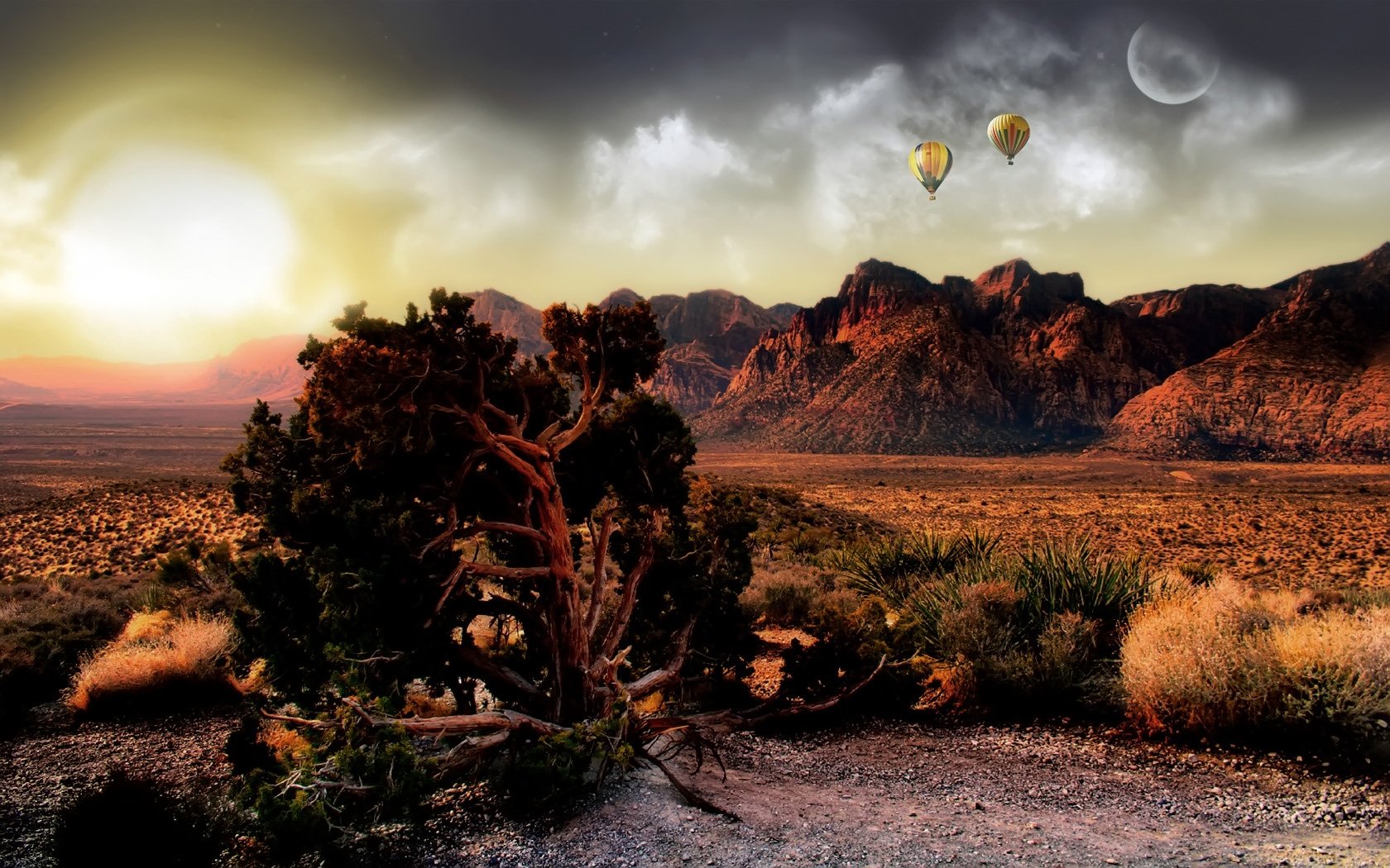 HD desktop wallpaper featuring a dramatic desert landscape at sunset with rugged mountains, two hot air balloons, and a large tree in the foreground under a cloudy sky.