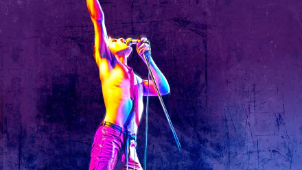 5K Ultra HD PC desktop wallpaper of a shirtless rock singer onstage, bathed in neon colors and gripping a microphone, from the movie Bohemian Rhapsody.