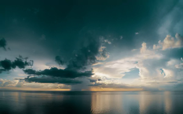 An 8K Ultra HD desktop wallpaper capturing a dramatic sky with clouds over a calm ocean at the horizon, showcasing the beauty of nature.