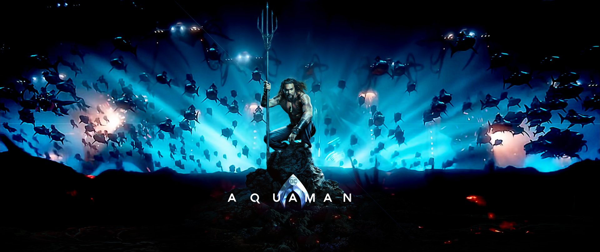 HD PC desktop wallpaper featuring Jason Momoa as Aquaman, standing with his trident amidst an underwater scene filled with glowing aquatic creatures.