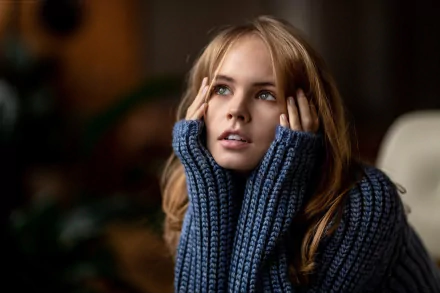 HD desktop wallpaper featuring Anastasiya Scheglova, a blonde Russian model, wearing a cozy blue sweater with a contemplative expression.