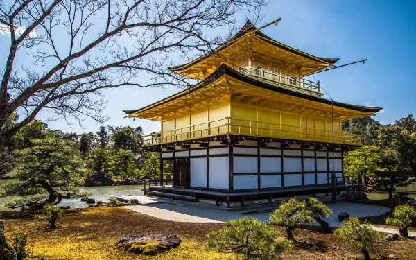 HD desktop wallpaper showcasing Kinkaku-ji, the iconic golden pavilion temple in Japan, surrounded by tranquil gardens and clear blue skies.