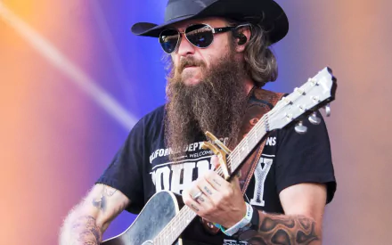 HD desktop wallpaper featuring musician Cody Jinks playing guitar onstage with a colorful background.