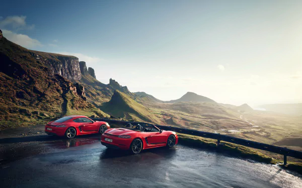Two red Porsche 718 Boxster GTS vehicles parked on a wet mountain road at sunrise, captured in a 4K Ultra HD PC desktop wallpaper and background.
