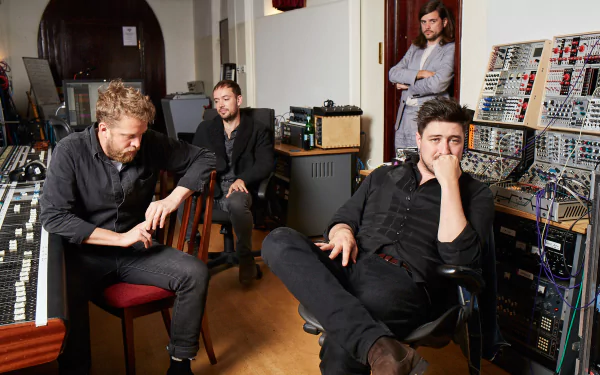 Mumford & Sons band members sitting pensively in a recording studio, ideal HD desktop wallpaper and background.