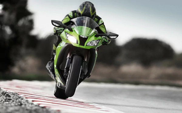 HD PC desktop wallpaper and background showing a green Kawasaki Ninja vehicle — a sport motorcycle leaning into a racetrack turn with a blurred background conveying speed.