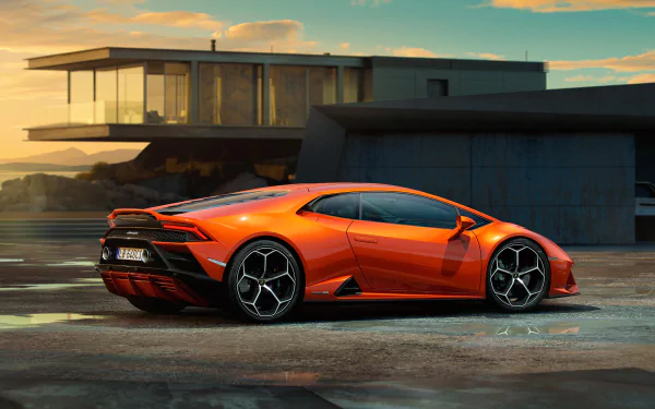 An orange Lamborghini Huracan Evo supercar parked beside a modern building at sunset, captured in stunning 8K Ultra HD quality.
