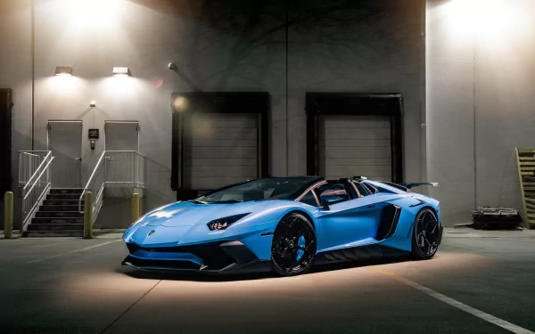 Blue Lamborghini Aventador SV supercar showcased in a dimly lit industrial setting, captured as an HD PC desktop wallpaper and background.