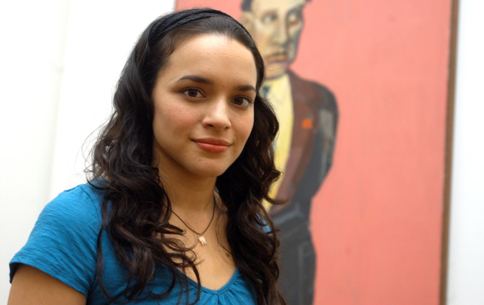 HD PC desktop wallpaper featuring a portrait of musician Norah Jones in front of a colorful background, capturing her calm and confident expression.