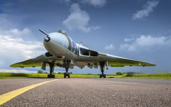 HD desktop wallpaper featuring a military Avro Vulcan bomber warplane on a runway under a cloudy sky.