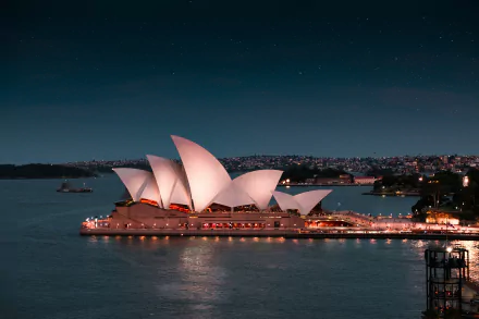 A stunning 4K Ultra HD image of the Sydney Opera House illuminated at night, showcasing iconic man-made architecture against the Sydney cityscape.