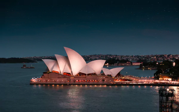 A stunning 4K Ultra HD image of the Sydney Opera House illuminated at night, showcasing iconic man-made architecture against the Sydney cityscape.