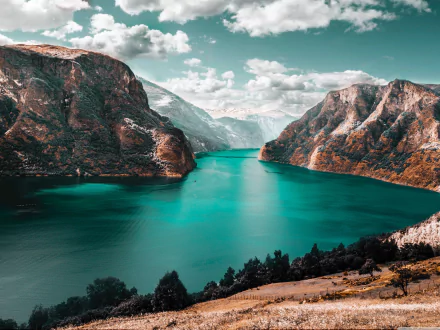 4K Ultra HD desktop wallpaper showcasing a serene fjord framed by rugged mountains under a partly cloudy sky, highlighting the beauty of nature.