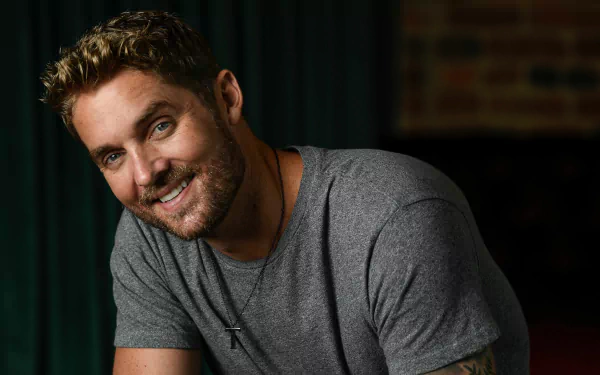 HD wallpaper featuring a smiling man in a grey t-shirt, providing a personable background for desktops.